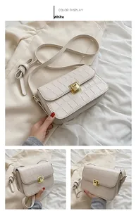 Close-up of white crocodile pattern shoulder bag with a square gold metal clasp