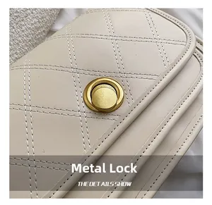 Detail of a beige quilted leather bag featuring a vintage round gold metal twist lock buckle