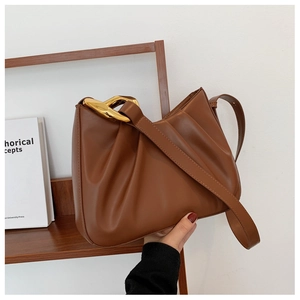 Close-up of brown pleated bucket bag featuring high-quality leather and gold chain detail