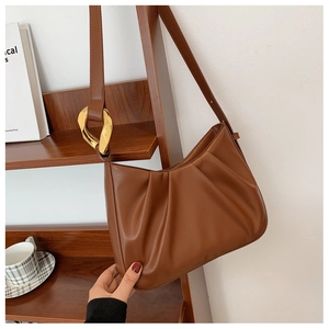 Detailed view of the brown ruched cloud bag featuring stylish thick gold chain link hardware