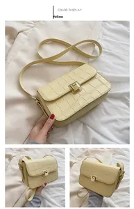 Detail of yellow crocodile pattern leather bag with gold buckle and adjustable strap