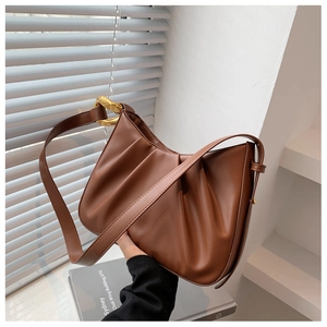 Detail view of the brown pleated leather cloud bag featuring chunky gold chain link hardware