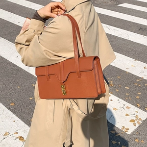 Vintage caramel brown leather underarm bag with gold metal buckle and dual strap detail