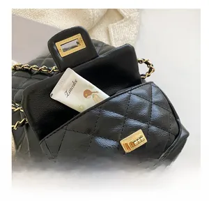 Detail of the front pocket of a black quilted leather mini backpack with gold hardware