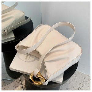 Detail view of the cream-colored pleated handbag with thick gold chain link hardware