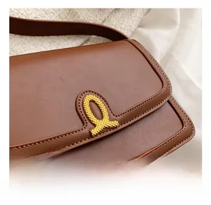 Detailed macro view of the gold irregular hardware clasp and brown leather texture