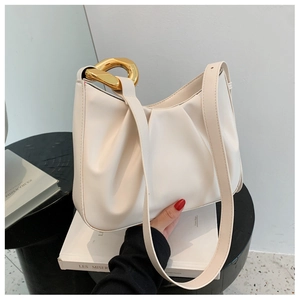 Detail of cream white pleated bucket bag with chunky gold chain handle and leather strap