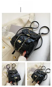 Detail of black quilted leather backpack with gold chain straps and turn-lock closure