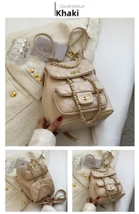 Detail of khaki quilted backpack featuring golden chain straps and turn-lock closure