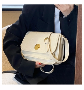 Close-up of cream white quilted PU leather crossbody bag with golden circular twist lock