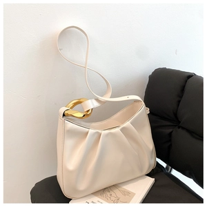 Detail of cream white pleated cloud bag with stylish gold metal chain strap connector