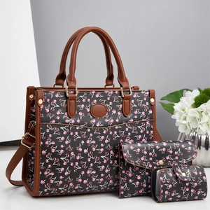 Détail de l'ensemble de 3 sacs avec imprimés cerises et finitions en cuir marron