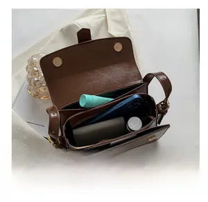 Interior view of brown vintage shoulder bag showing large capacity and multi-compartments