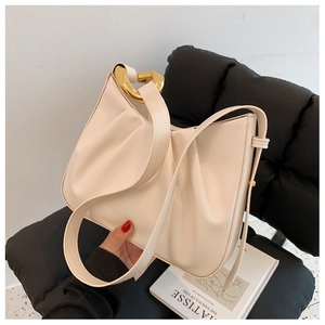 Detail of off-white pleated bucket bag featuring a bold gold chain buckle decoration