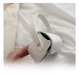 Détail du mini sac à main blanc crème avec motif à carreaux et bouton pression en métal