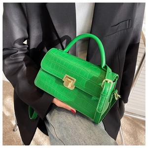 Dettaglio borsa a mano verde smeraldo con stampa coccodrillo e chiusura in oro lucido