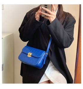 Macro detail of royal blue crocodile pattern bag with gold square metal clasp