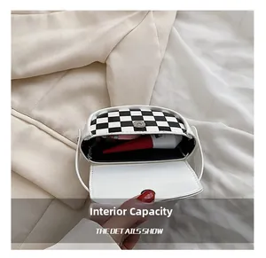 Capacité interne du mini sac selle à damier noir et blanc avec rouge à lèvres et objets