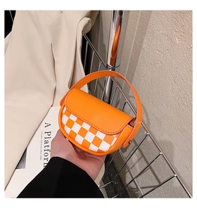 Détail du mini sac selle à damier orange et blanc avec poignée et coutures soignées