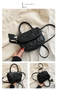 Detail view of black PU handbag featuring embossed bear patterns and heart charm accessory