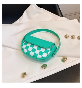 Détail d'un mini sac selle à damier vert et blanc posé sur un costume blanc chic