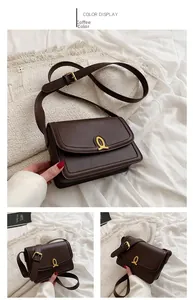 Detail of dark brown leather crossbody bag with vintage gold horseshoe buckle closure