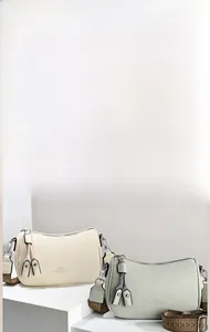 Dettaglio borsa a tracolla con grana elefante, tracolla intrecciata e nappe in beige e verde