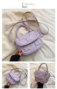 Detail view of purple small square bag with cloud texture and heart charm accent