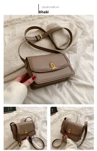 Khaki crossbody bag featuring a unique gold abstract ring hardware closure and texture