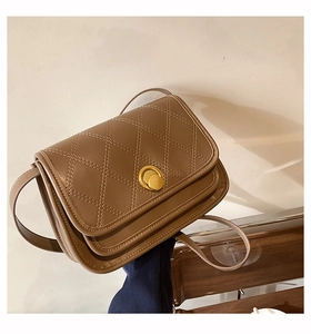 Close-up of brown quilted crossbody bag with golden metal twist lock and matte leather