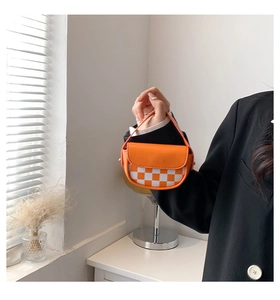 Détail du mini sac selle à damier avec rabat en cuir orange et poignée supérieure