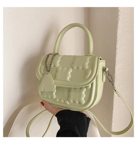 Detail of mint green handbag featuring 3D wave quilted texture and adjustable strap