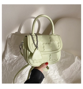 Detail of light green PU leather handbag featuring embossed cloud texture and chain charm