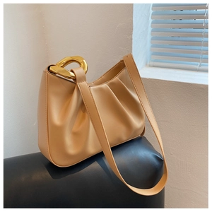 Detail of pleated beige bucket bag with thick gold chain and smooth matte texture