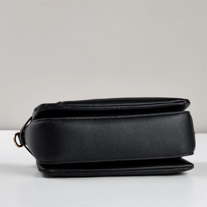 Vue détaillée du sac en cuir noir avec structure en accordéon à trois niveaux et anneaux dorés