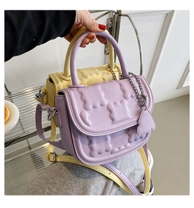 Detailed close-up of puffy quilted leather handbags in lilac and pale yellow hues