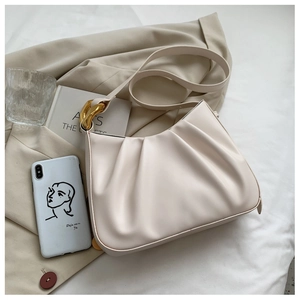 Detail of off-white pleated bucket bag featuring gold metal chain and soft PU leather