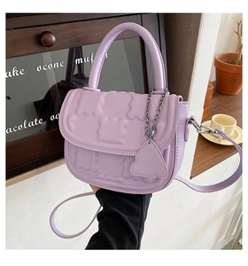 Detail view of light purple mini handbag featuring 3D embossed pattern and silver chain