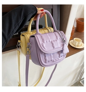 Close-up of lilac and yellow mini bags with embossed texture and metal chains