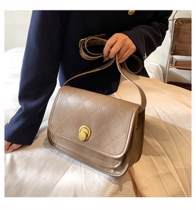 Detail of khaki quilted crossbody bag with golden ring twist lock and smooth texture
