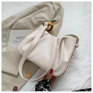 Detail of cream pleated cloud bucket bag with stylish gold circular ring buckle