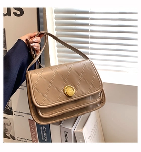 Close-up of khaki diamond quilted leather bag with a round gold twist lock closure
