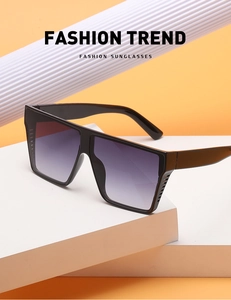 Close-up of oversized square sunglasses with black frames and gradient purple lenses