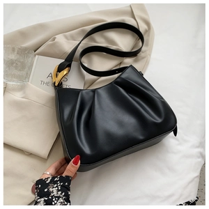 Detail of black pleated cloud bucket bag featuring a sleek gold metallic buckle closure