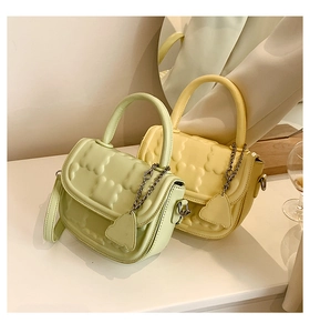 Detail of trendy mini bags with bear embossing and heart-shaped metal chain pendant