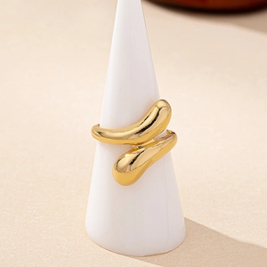 Minimalist golden snake ring with streamlined drop design on a white jewelry stand