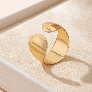 Macro detail of high-polish gold-tone open wide ring with teardrop ends on jewelry mat