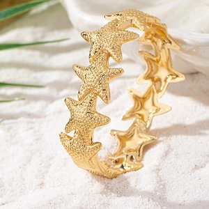 Chic gold starfish cuff bracelet for women featuring realistic texture on white beach sand