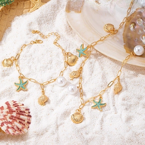 Close-up of ocean-themed necklace and bracelet with blue starfish and golden shell charms
