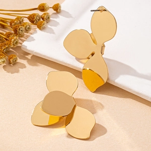 Boucles d'oreilles pétales dorées avec finition miroir sur fond texturé élégant